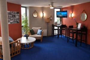 a hotel room with a waiting area with a tv at BRIT HOTEL Caen Hérouville in Hérouville-Saint-Clair