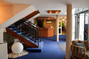 a lobby with a spiral staircase in a building at BRIT HOTEL Caen Hérouville in Hérouville-Saint-Clair