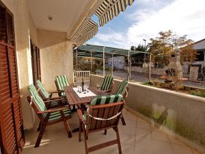 eine Terrasse mit einem Tisch und Stühlen auf dem Balkon in der Unterkunft Apartments Prostin 70 in Fažana