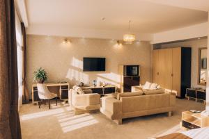 a living room with a couch and chairs and a table at Megapolis Hotel Shymkent in Shymkent