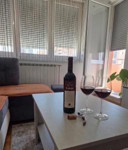 a bottle of wine and two glasses on a table at BK Apartment, Istocno Sarajevo, Lukavica in Lukavica +33 photos