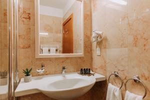 a bathroom with a sink and a mirror at Hotel Apoksiomen in Mali Lošinj