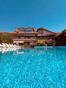a large swimming pool with chairs in front of a house at Villa Stefan Ohrid in Ohrid