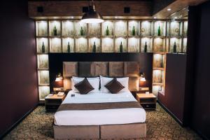 a bedroom with a large bed and some lights and lamps at Megapolis Hotel Shymkent in Shymkent +97 photos