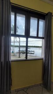 a window in a room with a view of a beach at Pousada Nova Onda in Paranaguá +5 photos