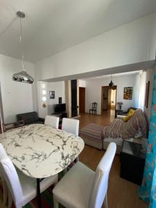 a living room with a table and white chairs at Casa Ferreira in Beja