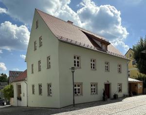 a large white building with a brown roof at Ferienwohnung im Künstlerhaus KUSCH in Schönsee