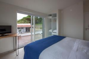 a bedroom with a bed and a view of a balcony at Hillside House Residence in Foz do Arelho +74 photos