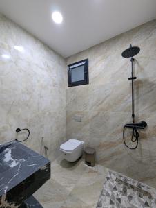 a bathroom with a toilet and a sink and a window at Azmouni in Midoun +6 photos