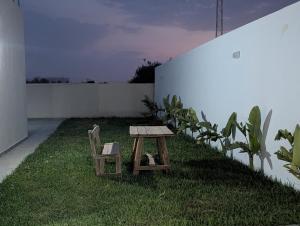 a table and a chair sitting on the grass at Azmouni in Midoun