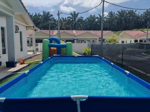 a pool with a water slide in a backyard at Homestay Amna DShorea in Port Dickson