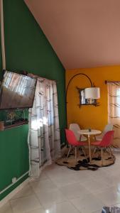 a room with a table and chairs and a green wall at Tsanta lodge in Talata-maty