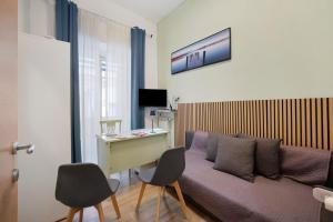 a room with a couch and a desk and chairs at Home Joséphine - Caserta in Caserta