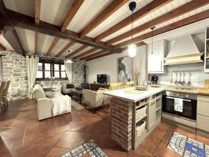 a kitchen and living room with a stone wall at Vivienda Vacacional La Cocada VV-144-AS in Arriondas