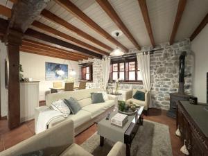 a living room with a couch and a stone wall at Vivienda Vacacional La Cocada VV-144-AS in Arriondas