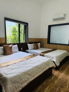 three beds in a room with a large window at Khách sạn Trọng Thiêm 1 in Ấp Thiện Lập +4 photos