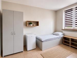 a small bedroom with a bed and a window at Kwatery pracownicze in Łódź