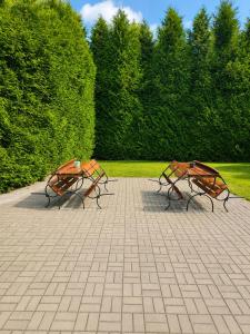 two benches sitting next to each other in a park at Kwatery pracownicze in Łódź +2 photos