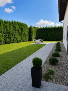 a garden with a patio with a table and bushes at Kwatery pracownicze in Łódź