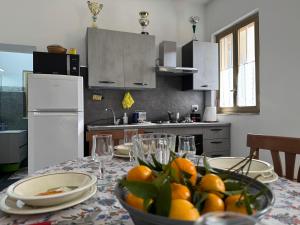 a kitchen with a table with a bowl of oranges on it at Villa Melia Apartments in San Roberto
