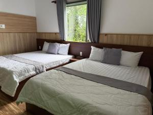two beds sitting in a room with a window at Khách sạn Trọng Thiêm 1 in Ấp Thiện Lập