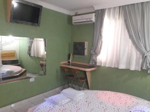 a bedroom with a bed and a desk and a mirror at Motel Sedução in Sao Paulo
