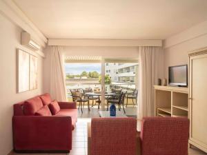a living room with a couch and a table with chairs at Ona Garden Lago in Port d'Alcudia