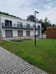 a building with benches and a street light in the grass at Apartmány Karolínka in Karolinka