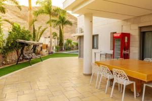 a patio with a table and a red coke machine at שאנל דירת גן עם בריכה in Eilat