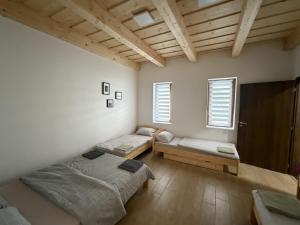 a room with two beds and two windows at Csitári-patak Vendégház in Csitár