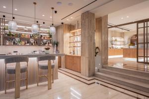 a kitchen with a bar with stools at Hotel Palmyra in Argassi