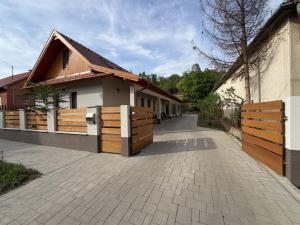a house with a fence next to a building at Csitári-patak Vendégház in Csitár