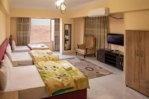 a hotel room with two beds and a television at Pyramita luxury hotel in ‘Ezbet `Abd el-Ḥamîd