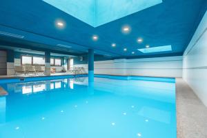 an empty swimming pool with blue ceilings at Residence Lagorai in Tesero