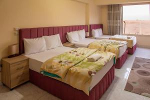 two beds in a hotel room with at Pyramita luxury hotel in ‘Ezbet `Abd el-Ḥamîd +10 photos