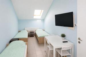 a small room with a table and a tv on the wall at Kwatery pracownicze in Łódź