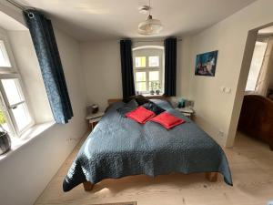 a bedroom with a bed with two red pillows at Ferienwohnung im Künstlerhaus KUSCH in Schönsee