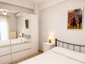 a bedroom with two beds and a painting on the wall at Vathy Central Residence in Samos