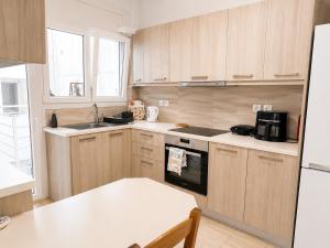 a kitchen with wooden cabinets and a stove top oven at Vathy Central Residence in Samos