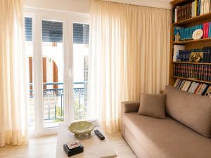 a living room with a couch and a book shelf at Vathy Central Residence in Samos +5 photos