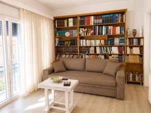 a living room with a couch and a book shelf with books at Vathy Central Residence in Samos