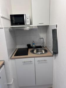 a small kitchen with a sink and a microwave at Studio 20m2 avec balcon in Corte