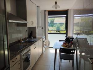 a kitchen with a sink and a table and a window at Confortable piso en Ares in Ares