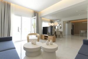 a living room with two white tables and a tv at Azoria Villa in Haraki