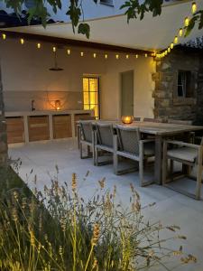 a patio with a table and chairs and lights at Hiša Marija Private Spa Villa in Zgornje Škofije