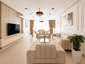 a living room with couches and a flat screen tv at Appartement Spacieux à Constantine in El Khroub +60 photos