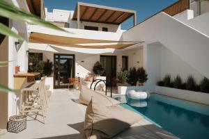 a home with a swimming pool and a house at The Lofts Paros Executive Suites in Naousa