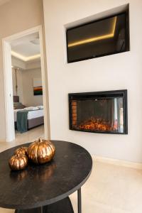 a living room with a fireplace and a table with pumpkins at Nino Suite, Central Pyrgos in Pyrgos