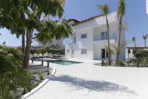 a villa with a swimming pool and palm trees at Azoria Villa in Haraki