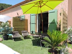 a patio with a table and chairs and an umbrella at Les Provences Bleu et Verte in Solliès-Pont